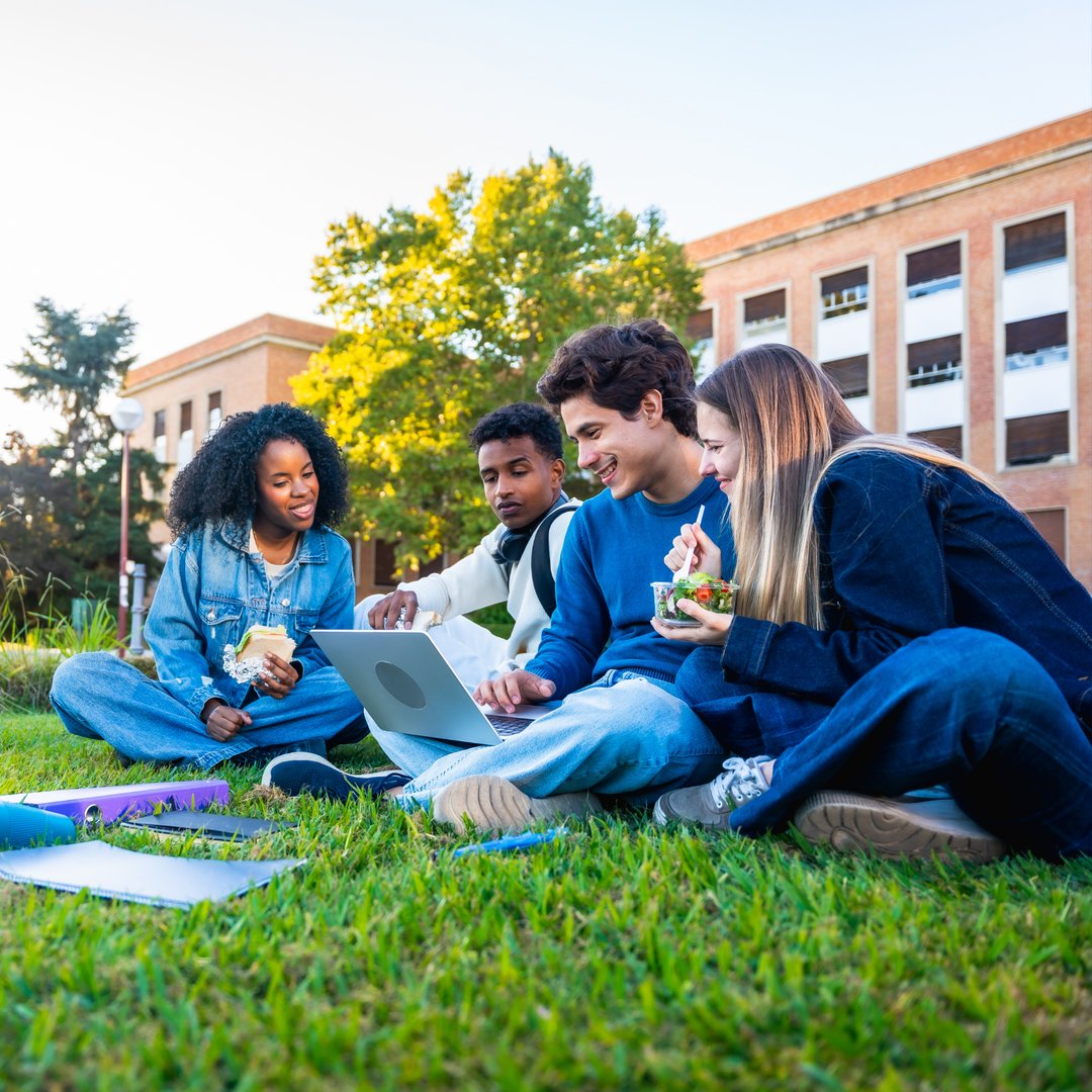 A group of students studying together with a laptop on campus
