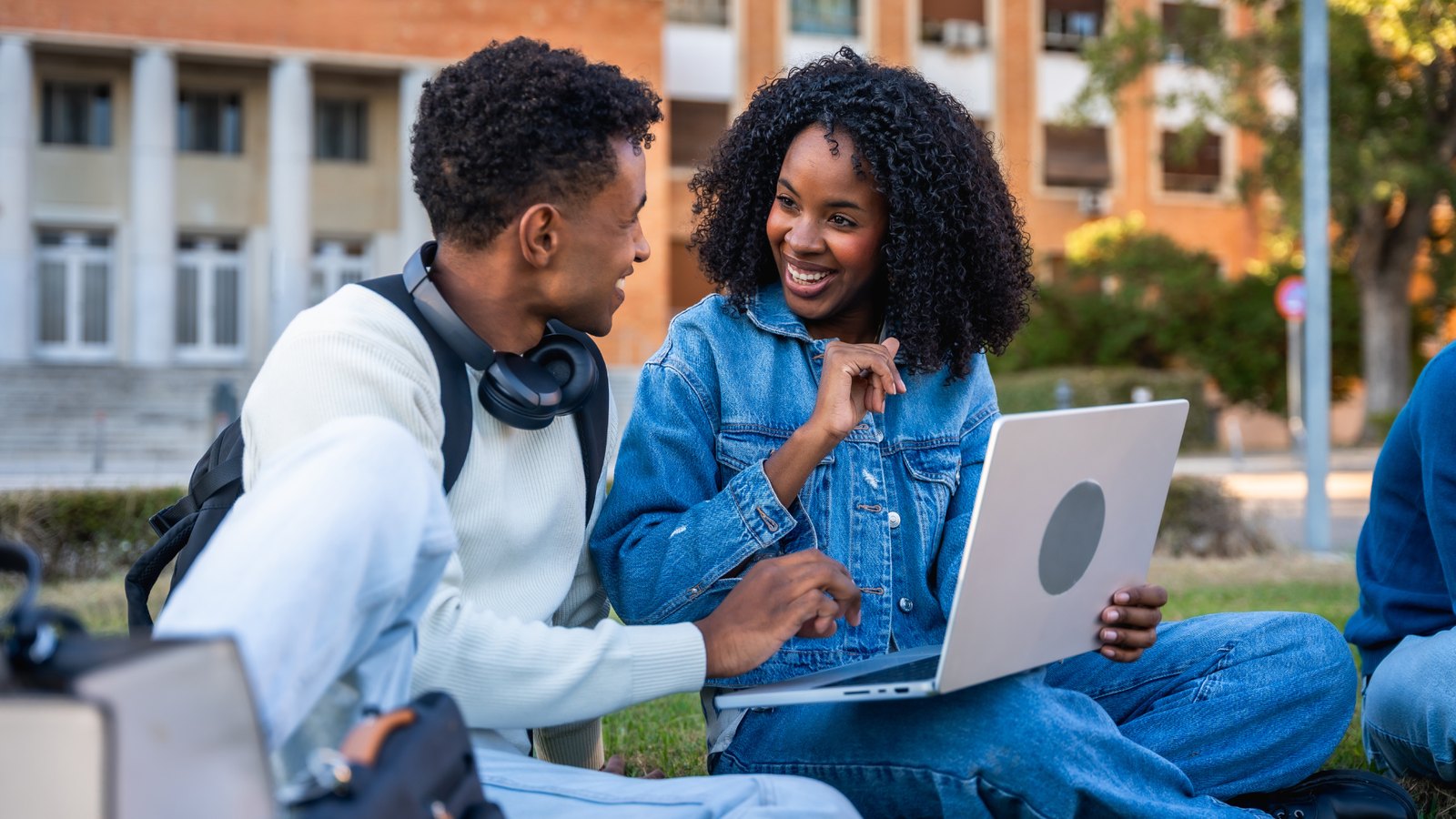 Students learning together on campus with a laptop